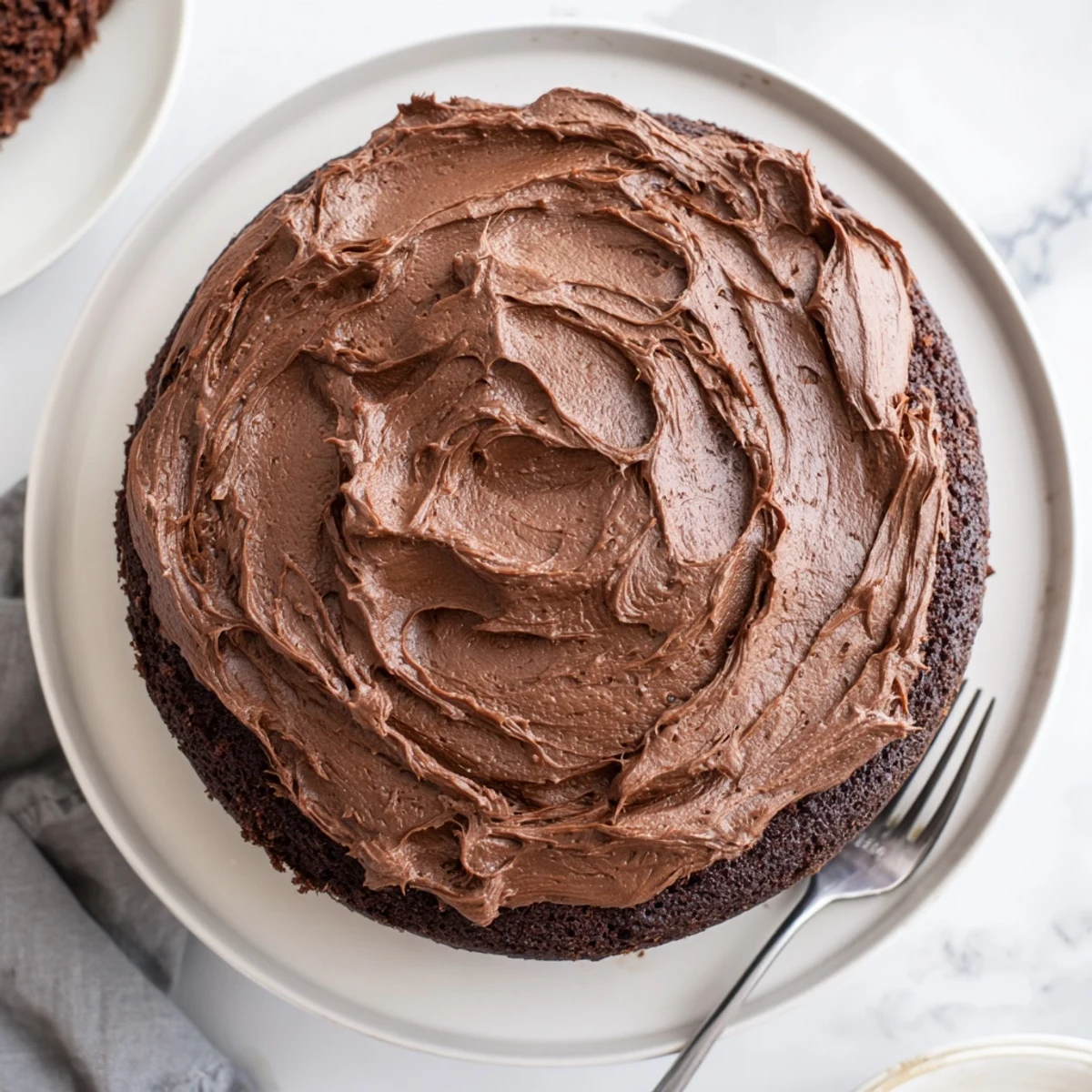 Rich Matilda chocolate cake layered with creamy frosting on a white serving plate
