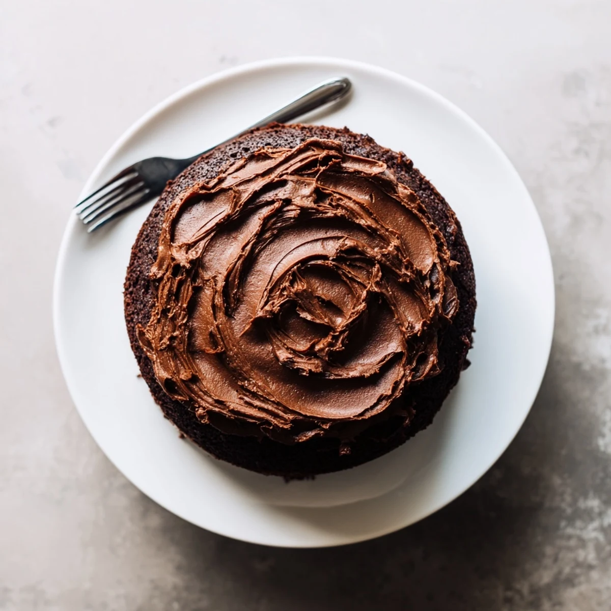 Moist Matilda chocolate cake slice revealing tender crumb topped with thick chocolate buttercream