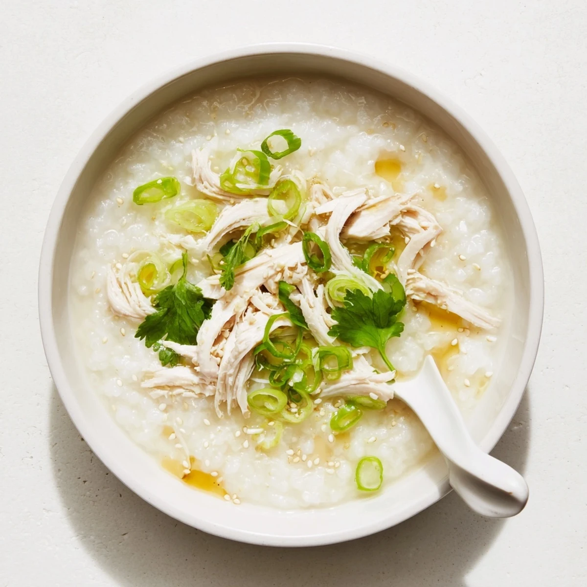 Savory Chinese chicken congee porridge served with sliced century eggs and crispy fried shallots