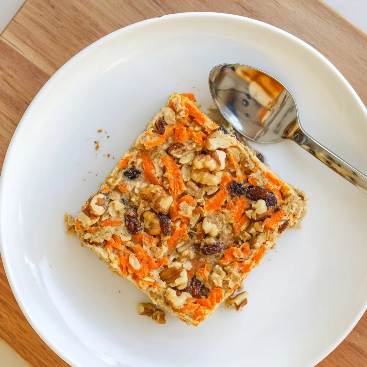 Warm slice of spiced carrot cake oatmeal topped with yogurt and extra maple syrup drizzle