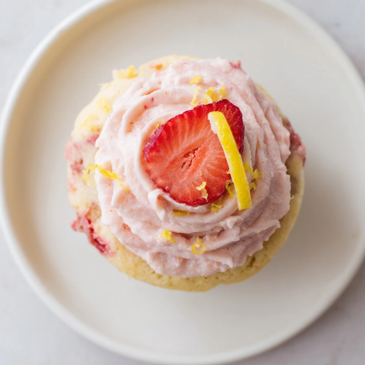 Fresh strawberry pieces baked into light lemon cupcakes topped with creamy pink frosting