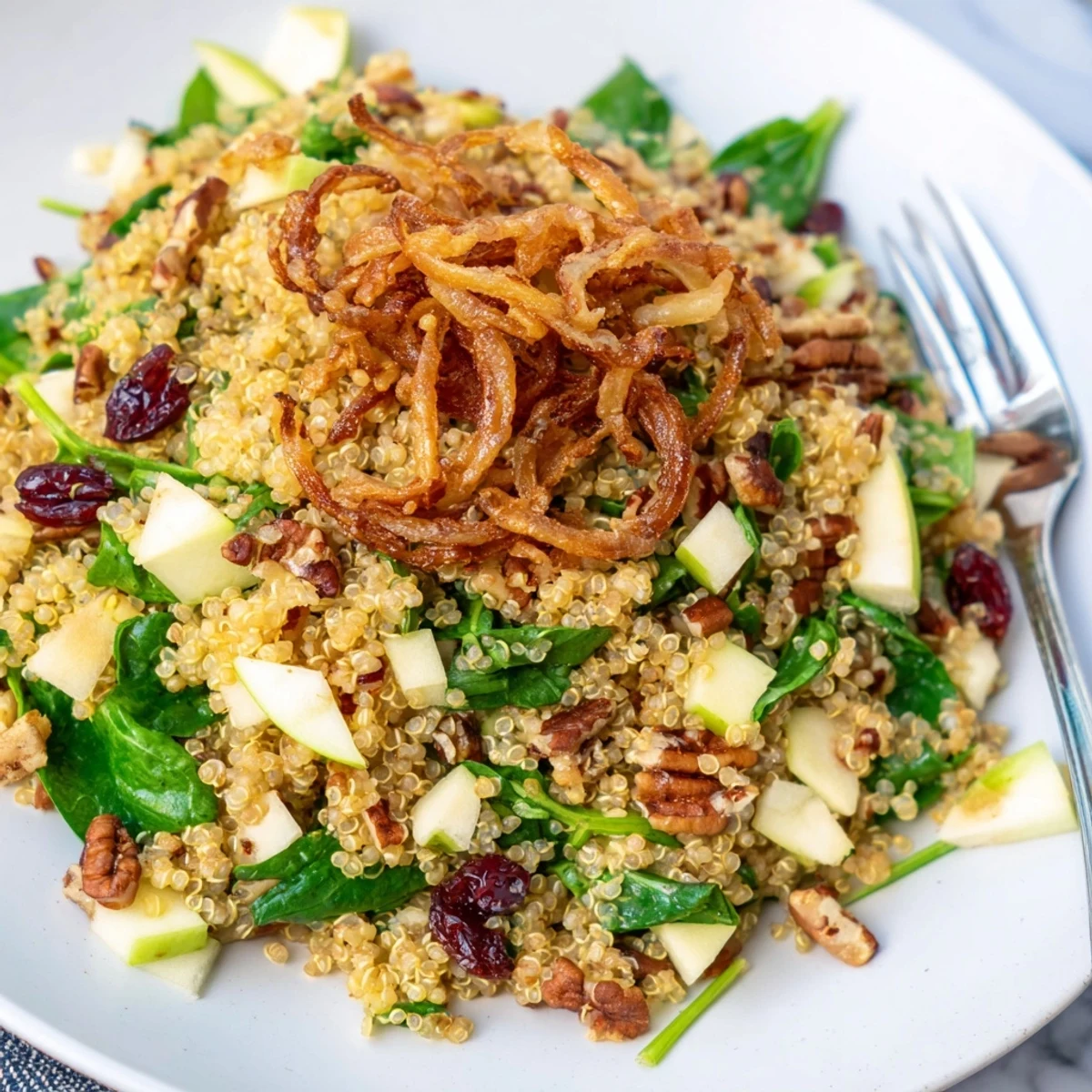 Fluffy quinoa tossed with diced apples spinach and tangy honey mustard dressing served fresh