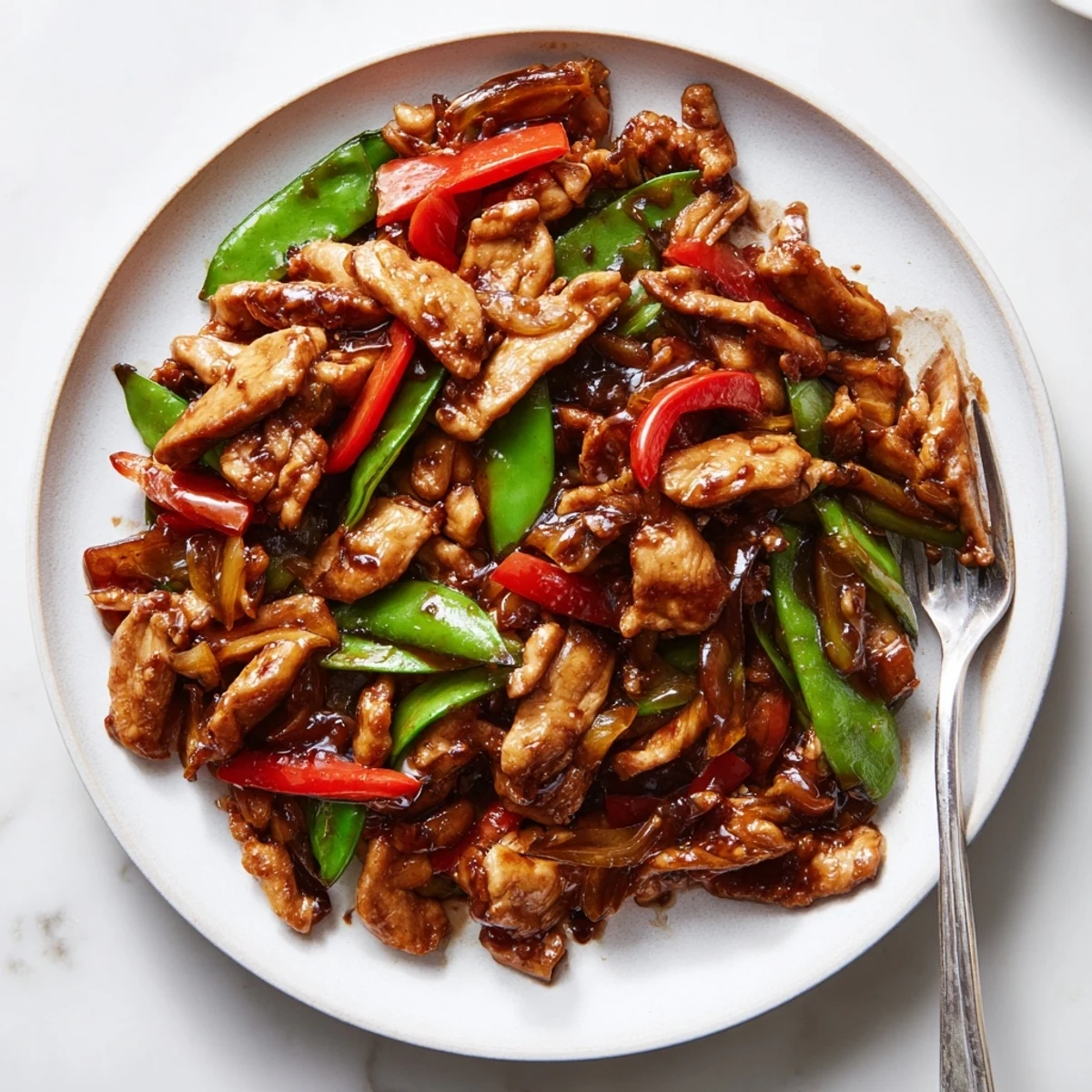 Golden stir fried Chinese garlic chicken served over steamed jasmine rice with scallions