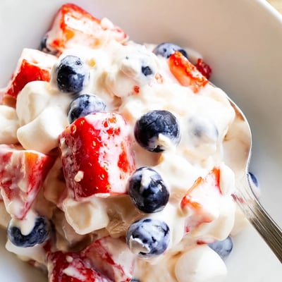 Red White Blue Cheesecake Salad served in a rustic bowl at a summer barbecue