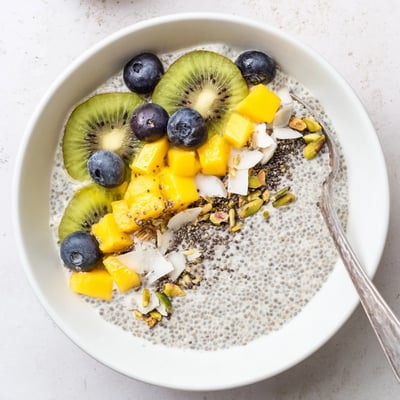 Chilled Coconut Chia Pudding in glass jars, vanilla-scented with fresh berries